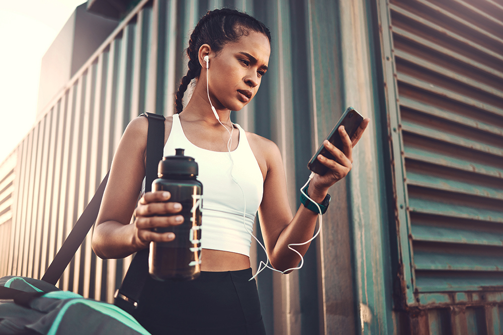 Woman heading to the gym looking at her phone